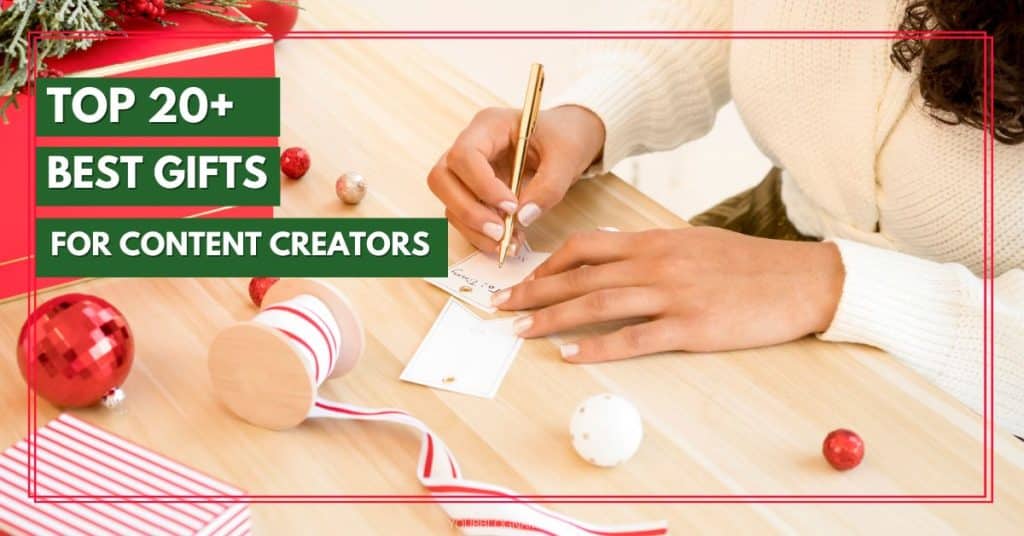 A person is seen writing on a small card with a gold pen at a wooden table. The table, adorned with red and white ornaments, candy canes, and a small gift box, sets the scene for finding the best gifts for content creators. Text on the image reads, "Top 20+ Best Gifts for Content Creators".