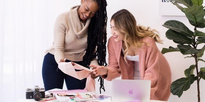 two women working together on a laptop