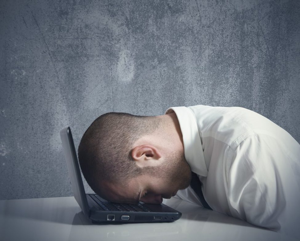 man with head on laptop trying to deal with failure