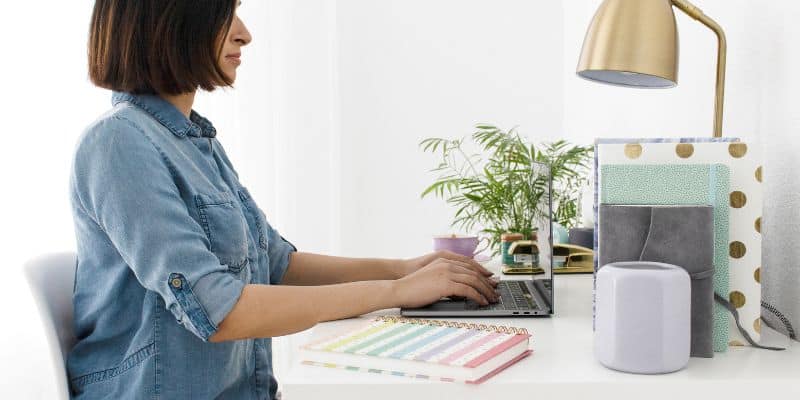 Proofreading woman wearing denim and working on her laptop