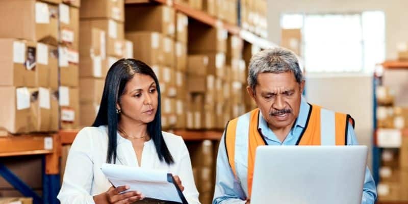 man and woman in shipping area with laptop