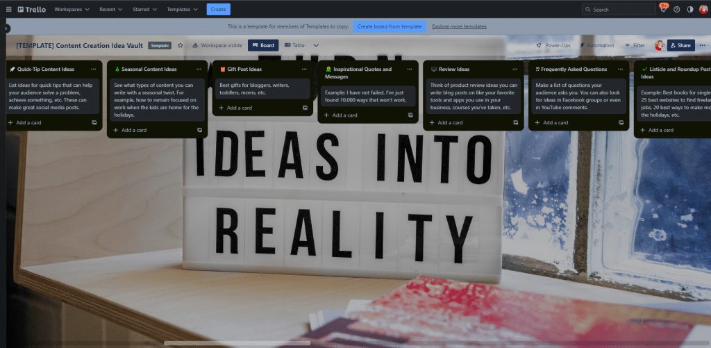 A Trello board titled "Content Creation Idea Vault" with various cards for content ideas. In the background, there's a lightbox that reads "IDEAS INTO REALITY" displayed next to a window dotted with raindrops—truly one of the best gifts for content creators looking to transform their inspirations.