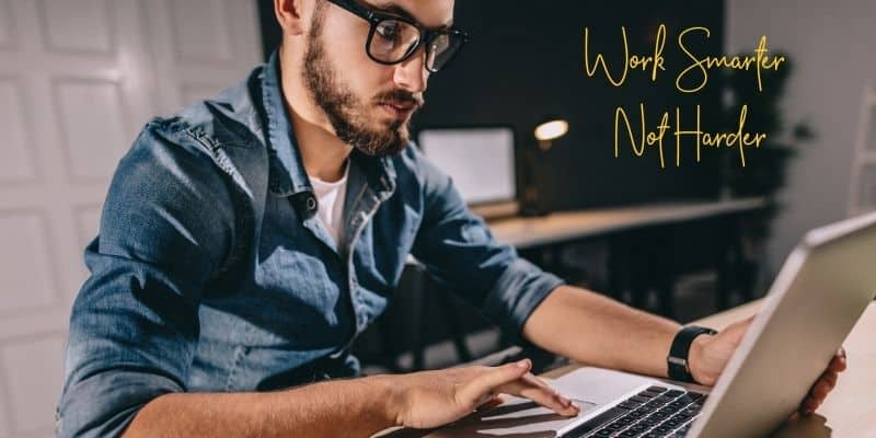 Work smarter not harder mastering your mindset man in a jean shirt and glasses on laptop