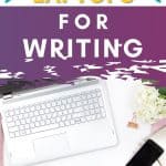 silver laptop, black smartphone and white flowers