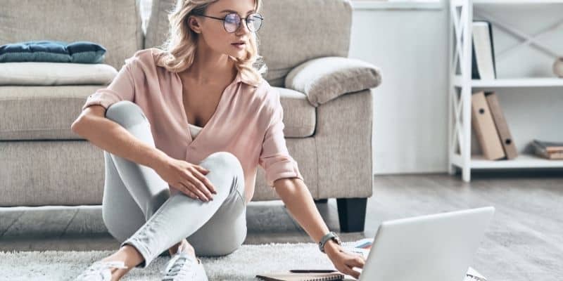 blog content woman in pink shirt on laptop on floor