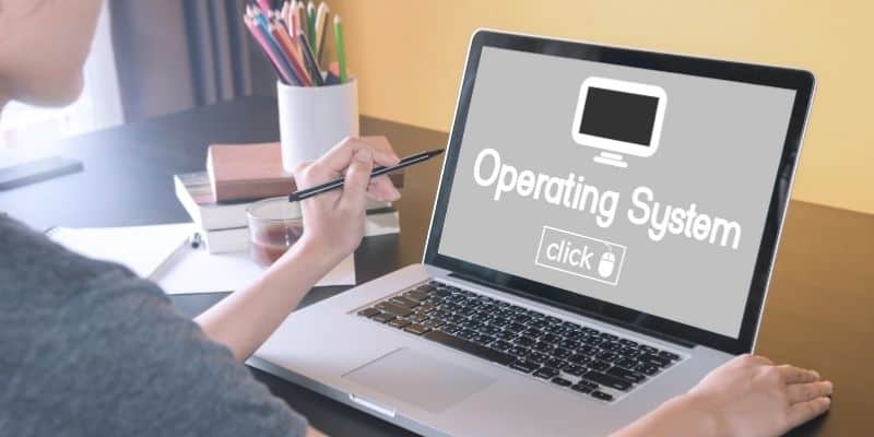 woman in a gray shirt on a laptop that says computer operating system