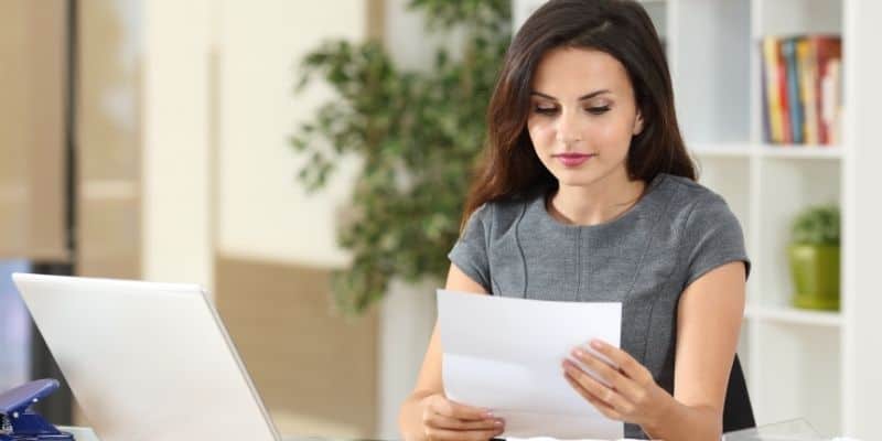 freelance writing cover letter woman in gray shirt at desk with letter