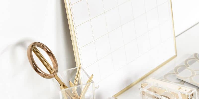 A desk with a gold calendar and a gold pen, representing the importance of maintaining a work-life balance.