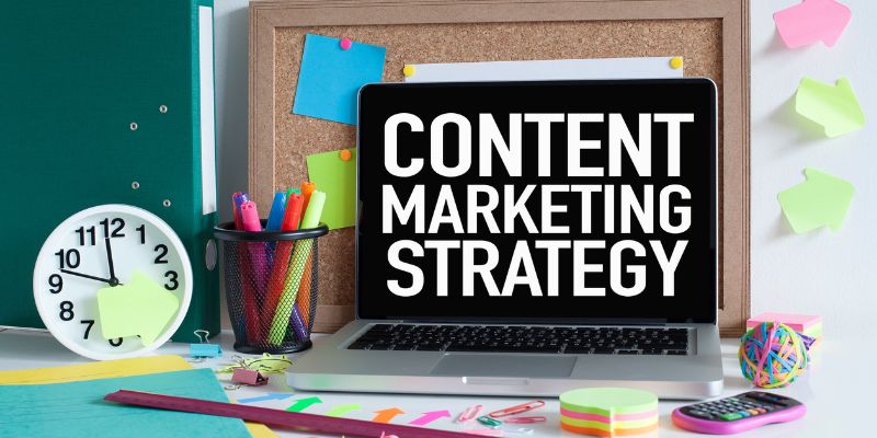 laptop with a sign that says content marketing strategy on a desk