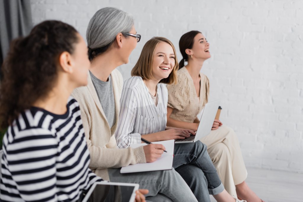 four women sitting down with notebooks