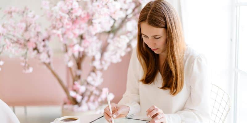 woman in a white shirt working on a ghostwriting project