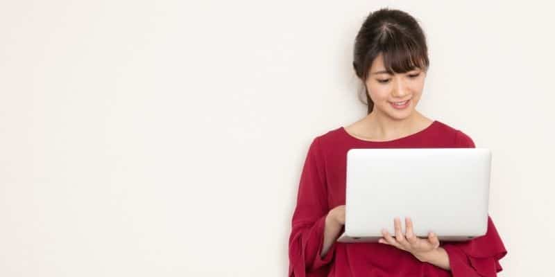 woman in red shirt holding computer