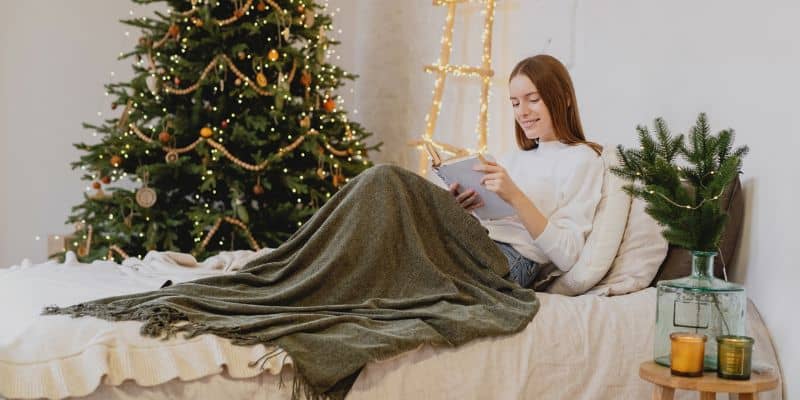 woman looking at her list of seasonal content ideas in front of a christmas tree