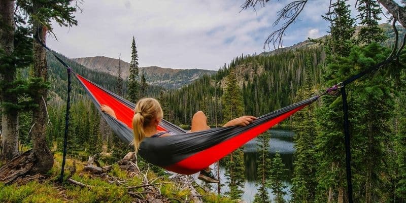 woman resting in a hammock on vacation so she can be more productive