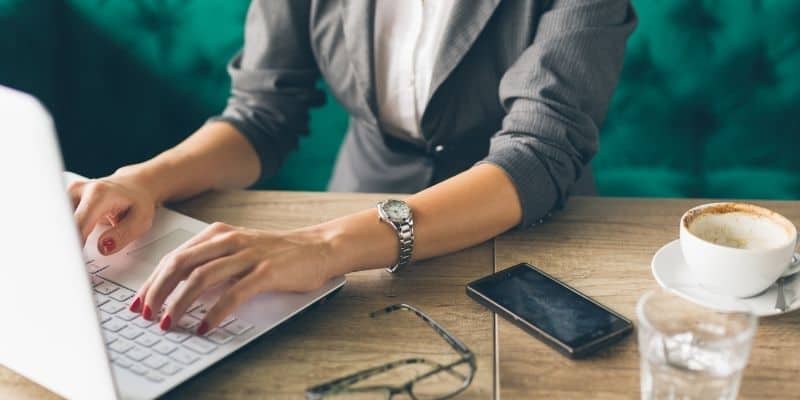 woman sitting at desk on computer learning how to use Trello to organize your life