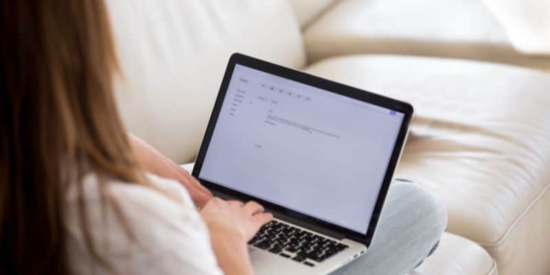 woman typing cover letter on laptop