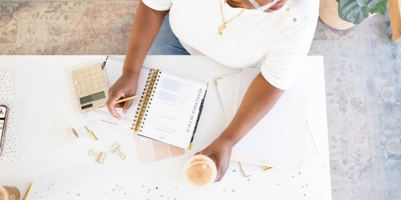 woman using a planner plan her week to be productive