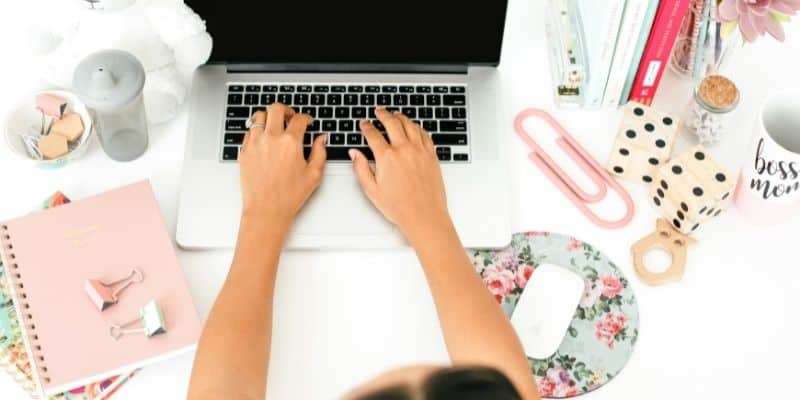 woman using persuasive business writing techniques on a laptop with flowered mousepad