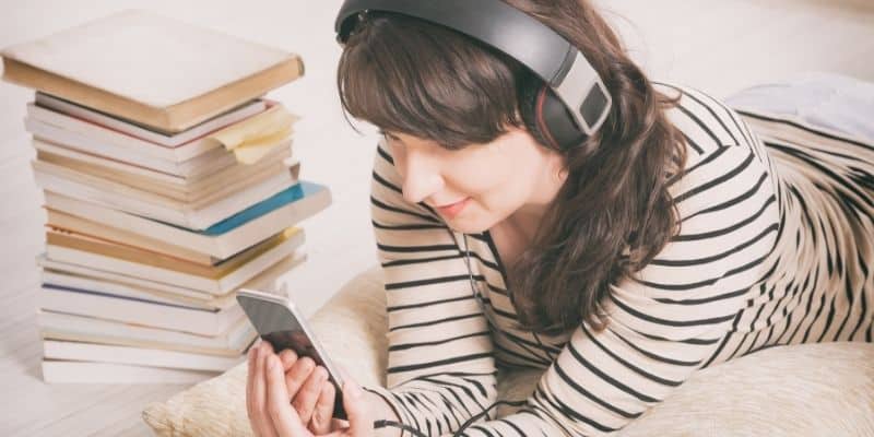 woman with headphones on listening to an audiobook -get paid to read books aloud