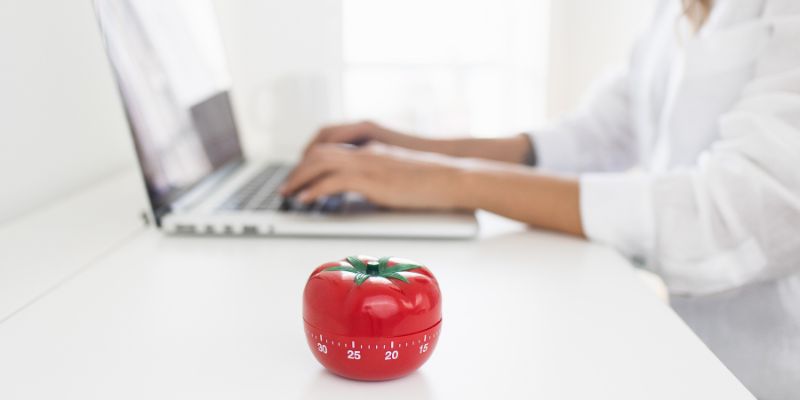 woman working on her computer with a Pomodoro timer