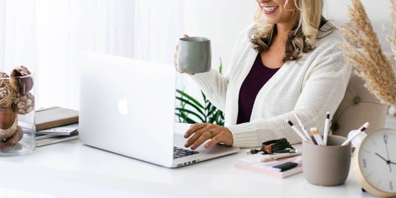 women with blond hair writing on her laptop